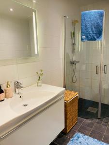 a white bathroom with a sink and a shower at Ljus och fräsch lägenhet i Ljungskile in Ljungskile