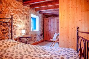 um quarto com uma cama num quarto com paredes de madeira em Refugio dos Cartolas em São Mamede
