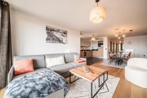 a living room with a couch and a table at Apartment Epicea Alpe d'Huez - by EMERALD STAY in L'Alpe-d'Huez