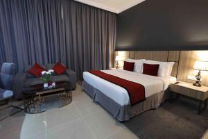 um quarto de hotel com uma cama grande e um sofá em Fortis Hotel Fujairah em Fujairah