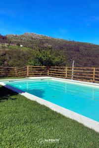 una piscina azul en el césped con una valla en Refugio dos Cartolas By ALPONTE, en São Mamede