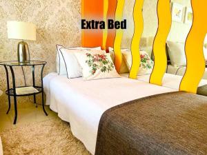 a bedroom with a bed with an orange and yellow wall at Cosy apartment in Queluz