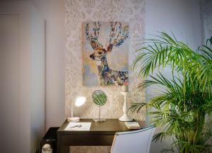 a desk with a painting of a deer on a wall at Cosy apartment in Queluz