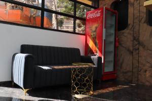 a coca cola machine sitting next to a couch at Hotel Golden Suites - Near Nesco in Mumbai