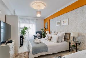 a bedroom with a large bed and a television at Cosy apartment in Queluz