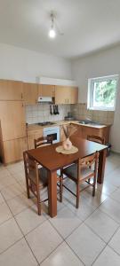 a kitchen with a table and some chairs and a table and a tablektop at KANALI HOLIDAYS APARTMENT in Kanali