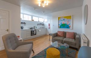 ein Wohnzimmer mit einem Sofa und Stühlen sowie eine Küche in der Unterkunft Fulwood Heights Apartments in Preston