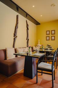 a restaurant with two tables and a couch and chairs at Calheta Beach - All-inclusive - Savoy Signature in Calheta