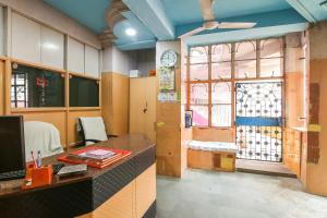 een kantoor met een bureau en een raam met een klok bij SPOT ON Hotel Amantran in Bhagalpur