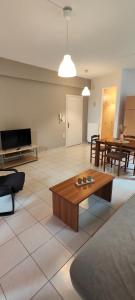 a living room with a couch and a coffee table at KANALI HOLIDAYS APARTMENT in Kanali