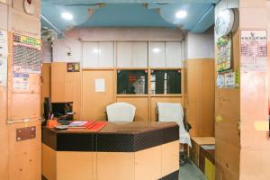 een bureau met stoelen en een klok bij SPOT ON Hotel Amantran in Bhagalpur