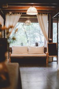 - un canapé dans une chambre avec une grande fenêtre dans l'établissement De Amor House & Coffee, à Sa Pa