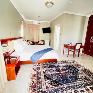 a bedroom with a bed and a table and a rug at Rosenia Boutique Hotel 20792 Block 3 in Gaborone
