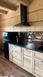 eine Küche mit Holzschränken und einer schwarzen Arbeitsplatte in der Unterkunft Siedlisko Huta Szklana in Bieliny