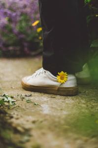une personne portant une fleur jaune dans ses chaussures dans l'établissement De Amor House & Coffee, à Sa Pa