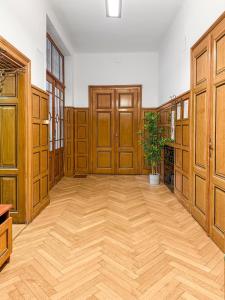 feworld - big living - city center Klagenfurt في كلاغنفورت: غرفة كبيرة ذات أبواب خشبية وأرضية خشبية