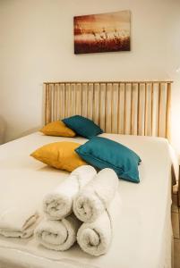 een bed met handdoeken en kussens erop bij T2 Climatisé avec Jacuzzi à 5 minutes des plages in Les Trois-Îlets