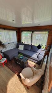 ein Wohnzimmer mit einem blauen Sofa und Stühlen in der Unterkunft Le Petit Cavron in Cavron-Saint-Martin