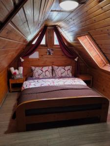 - une chambre avec un lit dans un grenier en bois dans l'établissement Dor de Munte Transfăgarasan, à Cârţişoara