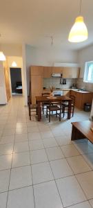 a kitchen and dining room with tables and benches at KANALI HOLIDAYS APARTMENT in Kanali