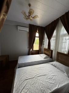 a bedroom with two beds and a ceiling fan at Zaynullo Guest House in Bukhara