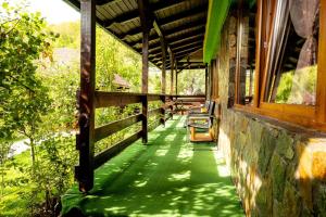 a building with a green walkway with benches on it at Pensiunea Namaesti - Inchiriere integrala in Nămăeşti