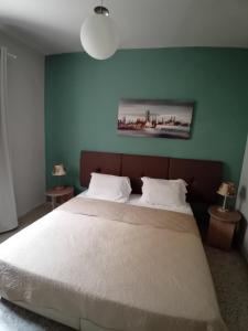 a bedroom with a large bed with a green wall at Mary's Place Stalis in Stalida