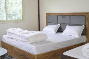 1 Schlafzimmer mit 2 Betten mit weißer Bettwäsche und Kissen in der Unterkunft Trishul Residency in Phata