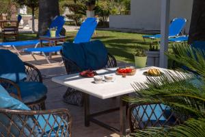 una mesa y sillas con fruta en el patio en Villa Dimitris Apartments & Bungalows by Imagine Lefkada en Lefkada