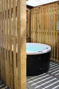 a hot tub sitting next to a wooden fence at Doolin Inn in Doolin