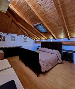 ein Schlafzimmer mit großem Bett und Holzdecke in der Unterkunft Loft House in Catania