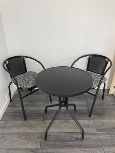 dwa krzesła i czarny stół i dwa krzesła w obiekcie Private room with shared bathroom in central of billund w Billund