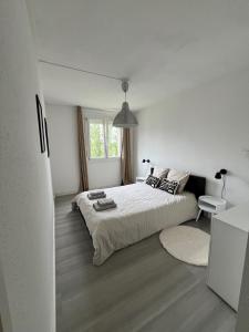 um quarto branco com uma cama e uma janela em COSY F3 PROCHE CENTRE em Belfort