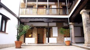um edifício com uma varanda com dois vasos de plantas em Apartamentos Inside Casa de la Alberca em Granada