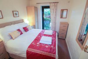 - une chambre avec un lit et une couverture rouge dans l'établissement Barn Owl Cottage, Lindale, à Lindale