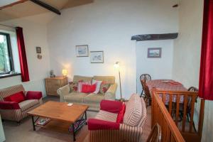 - un salon avec un canapé, des chaises et une table dans l'établissement Barn Owl Cottage, Lindale, à Lindale