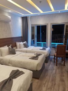een hotelkamer met drie bedden in een kamer bij tourist hotels cairo downtown in Caïro