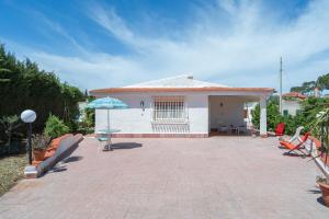 Casa con patio y sombrilla azul en Villa Nonna Anna a Plemmirio, en Siracusa
