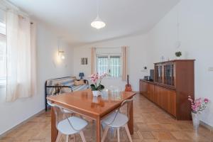 Una sala de estar con una mesa y sillas de madera. en Villa Nonna Anna a Plemmirio, en Siracusa