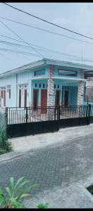 a blue building with red doors and a fence at Homestay selvi in Tlekung