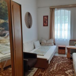 ein kleines Schlafzimmer mit einem Bett und einem Fenster in der Unterkunft Marika vendégház in Abádszalók