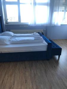 a large bed in a room with two windows at Zimmer in Ramstein in Ramstein-Miesenbach
