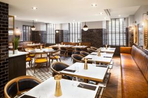 un comedor con mesas, sillas y mesa en Courtyard by Marriott Edinburgh en Edimburgo