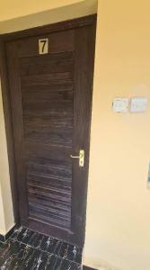 a wooden door with the number on it at Premara Hotel Kehancha 