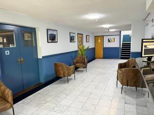 ストーニー・ストラットフォードにあるMK Hotelの椅子と青いドアのある待合室