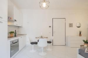 uma cozinha branca com mesa e cadeiras em Luce Apartment by Rent All Como em Como mais 42 fotografias