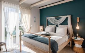 a bedroom with a canopy bed and a blue wall at Tyros Boutique Houses Villas in Tyros