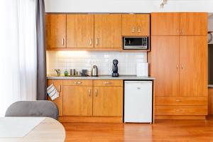Garay Panorama Apartment في بودابست: مطبخ بدولاب خشبي وثلاجة بيضاء