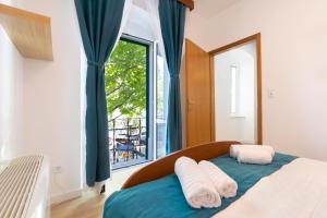 una camera da letto con un letto con due cuscini e una finestra di Bed and Breakfast Palac a Baška Voda