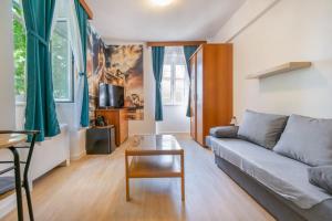 ein Wohnzimmer mit einem Sofa und einem Tisch in der Unterkunft Bed and Breakfast Palac in Baška Voda